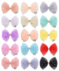 Vue détaillée de grandes barrettes à nœuds en résille avec paillettes étoiles et lunes