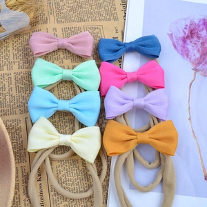 Lot de 8 bandeaux bébé colorés avec nœuds en gros-grain sur un fond de style vintage