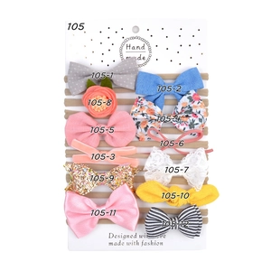 Détail d'un lot de 12 bandeaux pour bébé avec nœuds et fleurs sur carte support