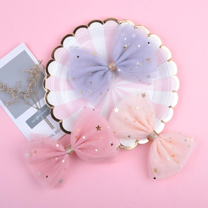 Vue détaillée des nœuds en tulle avec motifs d'étoiles et de lunes dorées pour filles