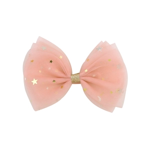 Détail du nœud rose en tulle pour cheveux avec des étoiles dorées et argentées brillantes