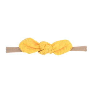 Détail du bandeau nylon bébé avec un nœud en velours côtelé jaune vif et élastique souple