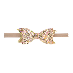 Détail du bandeau bébé avec nœud doré pailleté et bande élastique en nylon souple