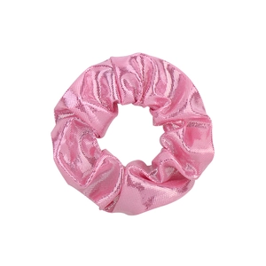 Détail macro d'un chouchou rose métallique avec un tissu brillant laser