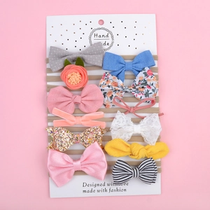 Lot de 10 bandeaux en nylon pour bébé avec nœuds variés sur carte d'affichage rose