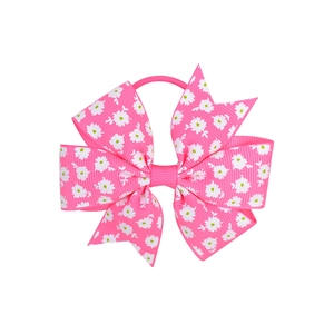 Detail of pink grosgrain ribbon hair bow with white daisy prints and elastic hair band