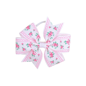Detail of white ribbed ribbon bow with pink rose floral print and wavy edge patterns