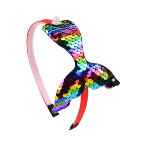 Détail du serre-tête en tissu rouge avec queue de sirène à paillettes colorées