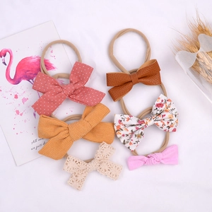Detail of baby headband set featuring cotton floral lace and PU leather bow textures