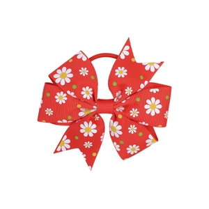 Detail view of red grosgrain ribbon bow with daisy print and elastic hair tie