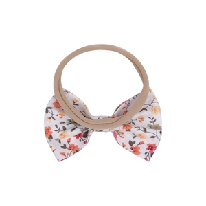 Detail view of baby floral bow headband made of soft nylon and printed cotton fabric