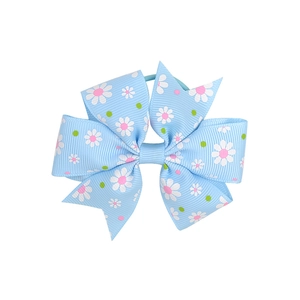 Detail of fishtail grosgrain ribbon hair tie with white daisy and polka dot pattern