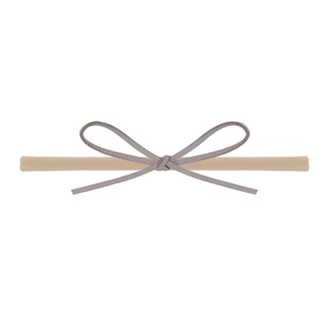 Close-up of baby nylon headband with grey faux suede bow on a clean white background