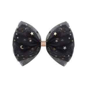 Detailed macro view of black mesh bow hair clip with gold star and moon sequins