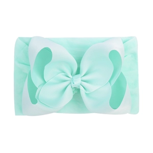 Close-up of mint green jacquard baby headband showing the ribbed bow texture and high elasticity