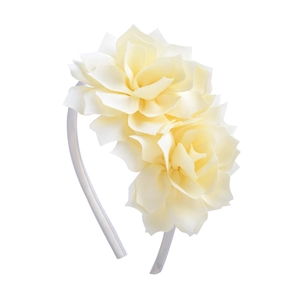 Détail de pétales de rose en tissu jaune crème sur un serre-tête blanc fin pour filles