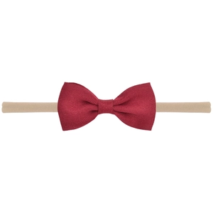 Detailed macro shot of burgundy ribbed fabric bow on seamless nylon baby headband