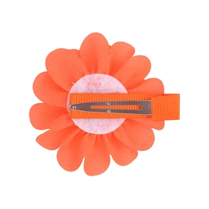Detail view of the back of an orange chiffon flower hair clip with a ribbon-wrapped metal base