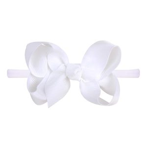 Detail shot of the white ribbed fabric bow headband showing elastic nylon band texture