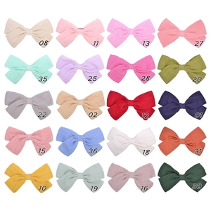 Close-up of 20 colors of cotton linen bow hair clips with textured fabric details