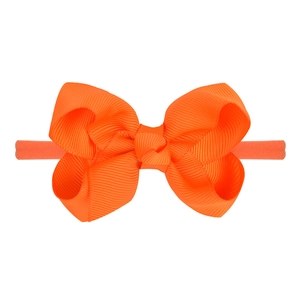 Detailed close-up of the orange grosgrain ribbon bow with high-elastic hair band