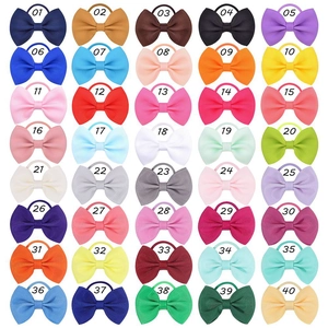 Detail showing 40 colorful grosgrain ribbon bow hair ties in a neat grid layout