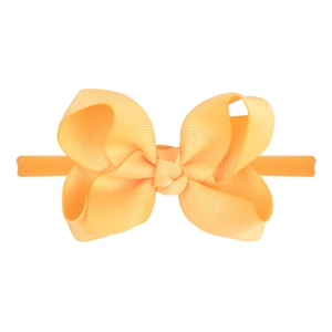 Close-up detail of orange solid bow headband with ribbed texture and elastic nylon band