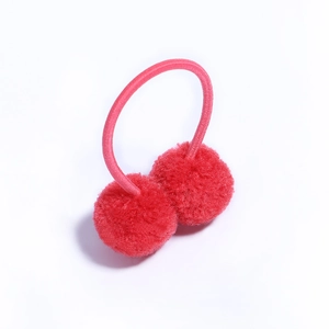 Detail shot of a pink elastic hair tie with two soft red plush pom-pom balls for kids