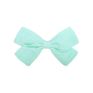 Detailed texture of light mint green linen bow hair clip showing woven fabric fibers