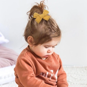 Pince à cheveux nœud en lin jaune moutarde faite main sur une petite fille
