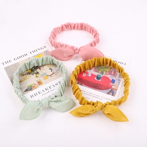 Detailed view of elastic bow headbands in pink, mint green and yellow colors