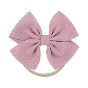 Close-up of baby bow headband with pink crinkle texture fabric and nylon band