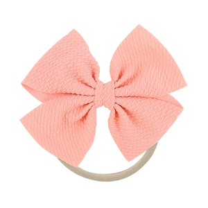 Detailed macro view of pink waffle fabric texture on soft newborn bow headband
