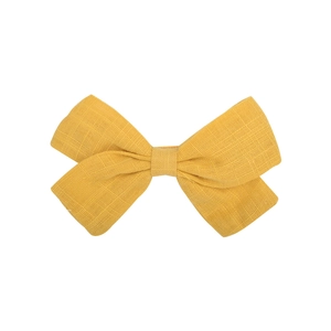 Close-up of a yellow cotton bow hair clip showing detailed linen texture and double layers