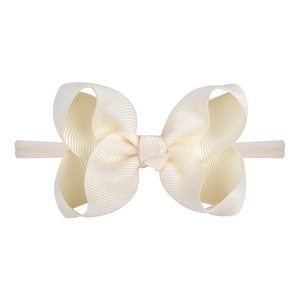 Macro shot of cream bow baby headband made of textured grosgrain ribbon and elastic nylon