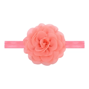 Detailed macro view of soft coral pink chiffon layered flower on elastic nylon baby headband