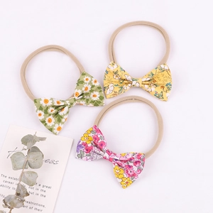 Vue détaillée de trois bandeaux pour bébé à fleurs avec sangles en nylon élastique