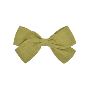 Close-up detail of grass green linen bow hair clip showing natural woven fabric texture
