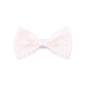 Close-up of white lace bow hair clip with intricate hollow pattern and satin center knot