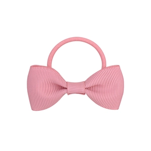 Detailed view of pink ribbon bow hair tie with textured grosgrain fabric and elastic band