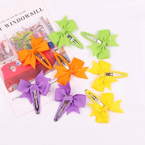 Close-up of colorful grosgrain ribbon bow hair clips set on a clean white background