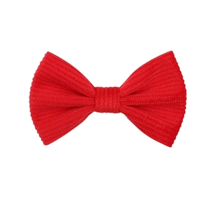 Close-up of red ribbed corduroy bow hair clip for girls with soft textile texture