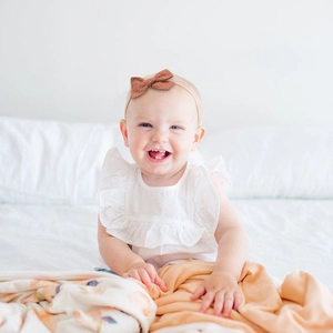 Detailed view of caramel baby headband with white polka dots on high elastic soft nylon band