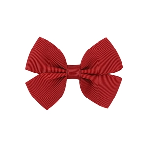 Detailed close-up showing the textured red grosgrain ribbon of a girls hair bow