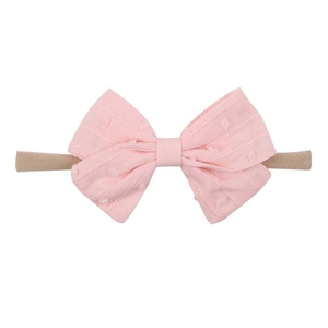 Soft light pink baby nylon headband with 3D textured cotton bow on white background