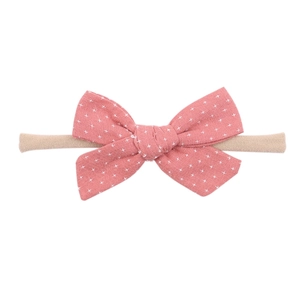 Baby pink bow headband made of soft nylon with white star pattern for infants
