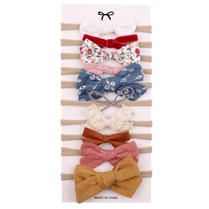 10-piece baby bow headband set in various fabrics like velvet and lace on elastic bands