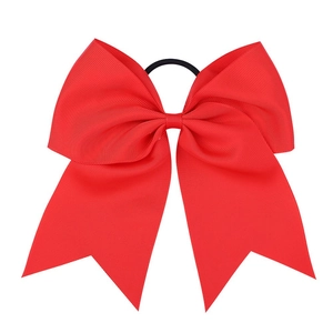 Detail of red grosgrain ribbon bow with textured weave and elastic black hair tie