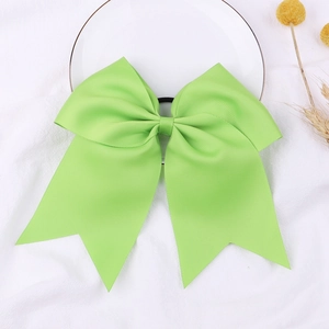 Fluorescent green 8-inch grosgrain ribbon bow hair tie with dovetails on white ceramic plate