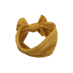 Detailed texture of baby nylon headband featuring a large mustard yellow jacquard bow